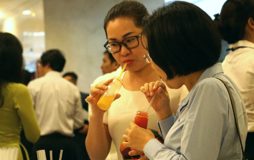 Một số kh&aacute;ch mời nếm thử nước tr&aacute;i c&acirc;y sản xuất bằng c&ocirc;ng nghệ HPP. Ảnh: Viễn Th&ocirc;ng