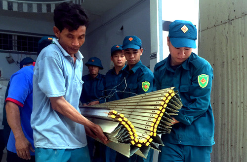 Lực lượng chức năng hỗ trợ người d&acirc;n di tản t&agrave;i sản. Ảnh: Cửu Long.