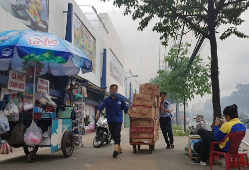Nh&acirc;n vi&ecirc;n si&ecirc;u thị k&eacute;o h&agrave;ng h&oacute;a di dời. Ản:Sơn H&ograve;a