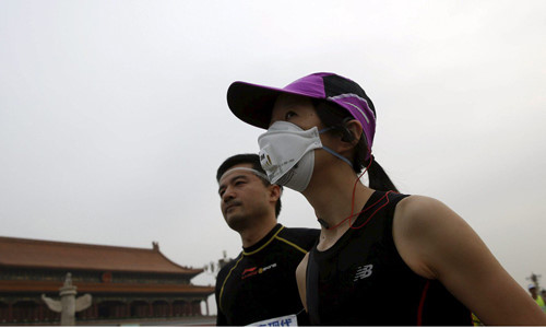 Runner phải đeo khẩu trang vì ô nhiễm không khà ở Bắc Kinh. Ảnh: Reuters