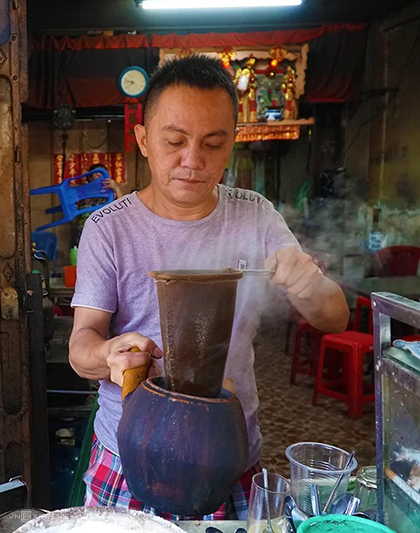 Anh Hùng tự tay chế từng mẻ cà phê bằng chiếc vợt quen thuộc. Ảnh: Phong Vinh.