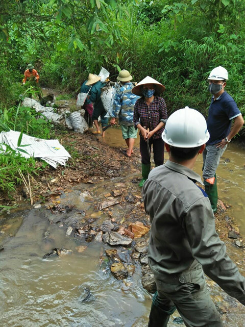 Người dân xã Phú Minh được thuê vớt dầu loang trên suối Trâm ngày 9/10. Ảnh: Người dân cung cấp