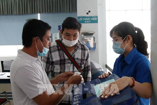 Hành khách nhận số thứ tự để chờ tới lượt mua vé tại ga Sài Gòn. Ảnh: Tiến Lực – TTXVN